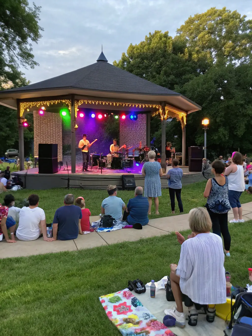 A vibrant photo of community members enjoying a concert outdoors, with diverse age groups and backgrounds.